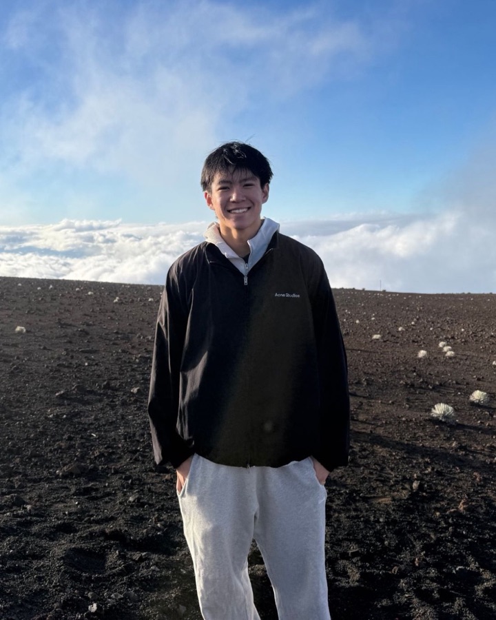 Michael Wang smiling on the summit of Haleakalā above the clouds